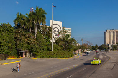 Cars on road with buildings in background