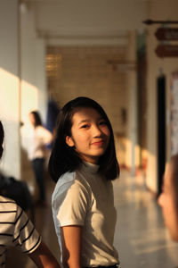 Portrait of smiling girl standing in corridor