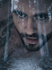 Close-up portrait of young man looking through window