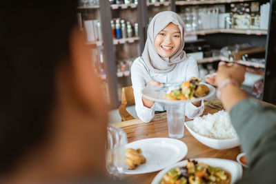 Portrait of smiling woman eating food in clinic