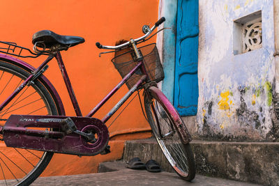 Bicycle parked on wall by footpath