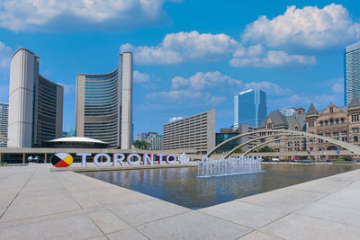 Modern buildings in city against cloudy sky