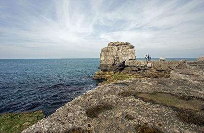 Rock formation on beach against sky