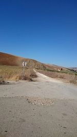 Dirt road against clear blue sky