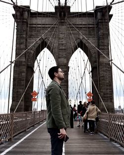 Low angle view of man walking on bridge