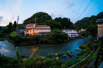 River by buildings against sky at dusk