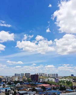 Aerial view of buildings in city against sky