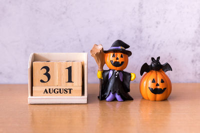 Close-up of pumpkin against yellow wall during halloween