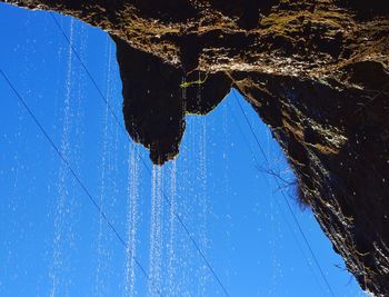 Low angle view of wet spider web against blue sky