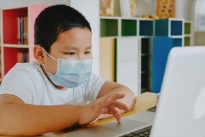 Boy using laptop while sitting by table