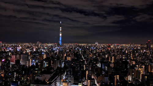 Illuminated cityscape against sky at night