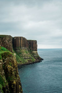 Rock formations by sea against sky