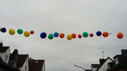 Low angle view of balloons against sky