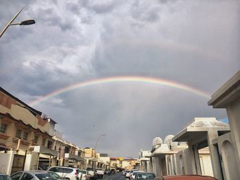 Low angle view of rainbow over buildings in city
