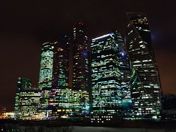 Low angle view of illuminated buildings against sky at night