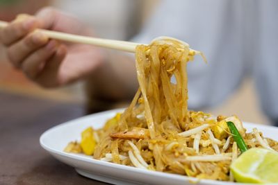 Close-up of a hand holding food in plate