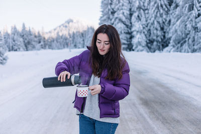 Portrait of young woman standing on snow