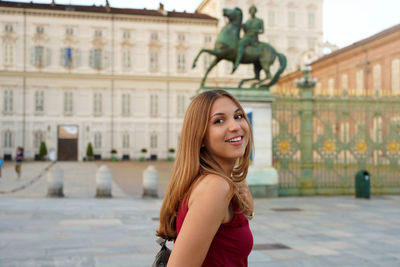 Travel in europe. attractive girl in italy with royal palace of turin on the background.