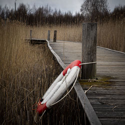 Wooden post on field by lake