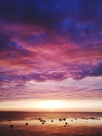 Scenic view of sea against dramatic sky during sunset