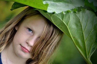 Close-up of boy standing under leaves