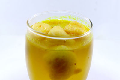 Close-up of drink on glass against white background