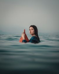Portrait of young woman with buoy in sea