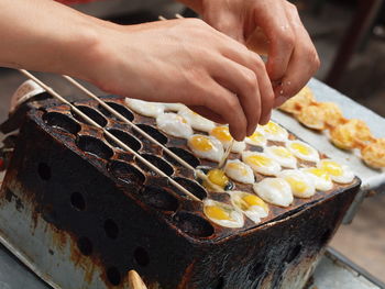 Cropped image of vendor cooking eggs