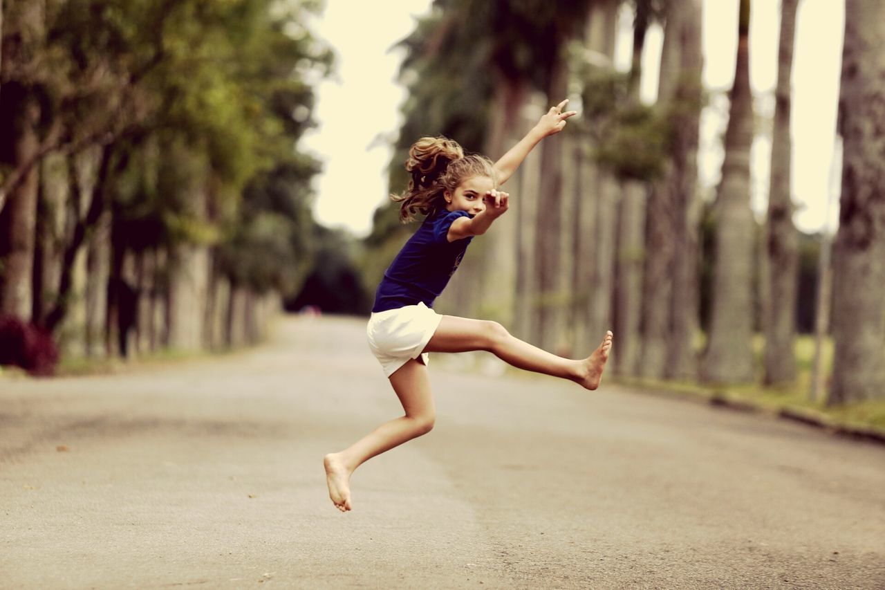 full length, jumping, lifestyles, mid-air, leisure activity, young adult, casual clothing, person, arms outstretched, balance, focus on foreground, fun, motion, enjoyment, skill, carefree, vitality, arms raised