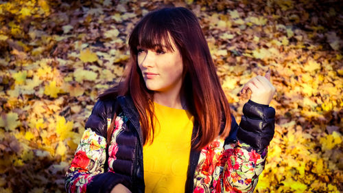 Young woman wearing mask in autumn leaves