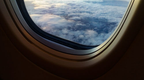 Close-up of airplane window against sky