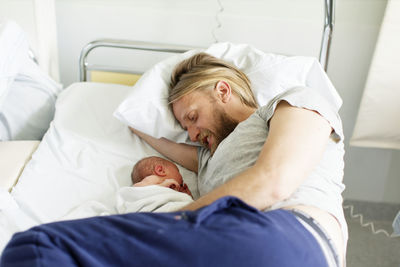 Midsection of man sleeping on bed