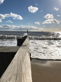 Wooden pier on sea against sky