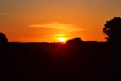 Scenic view of silhouette landscape against orange sky