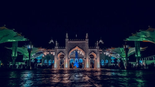 Illuminated building against sky at night