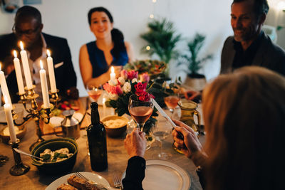 Woman raising toast with wineglass in dinner party at home