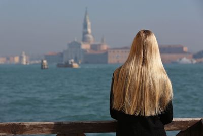 Rear view of woman standing against sky