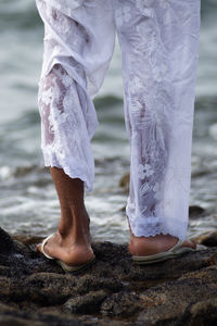 Person entering sea water wearing a long dress.