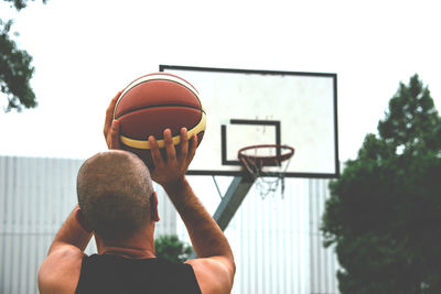 Rear view of man playing basketball