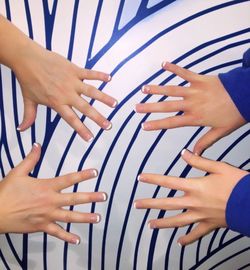 Cropped hand of mother and daughter showing nail polish on white and blue table