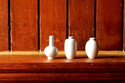 Close-up of vase on table against wall