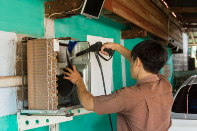 Rear view of young man working in workshop