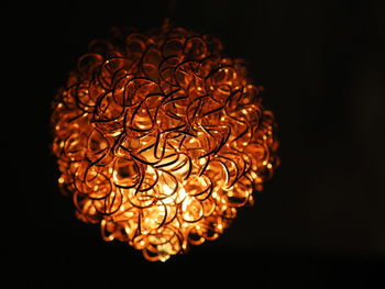 Close-up of illuminated lighting equipment against black background