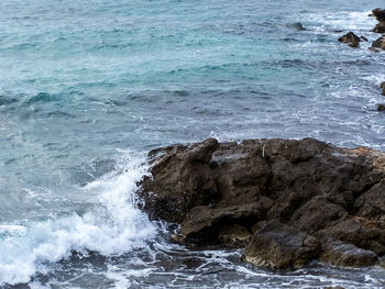 Close-up of rocks in sea against sky