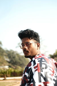 Low angle view of young man standing against sky