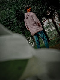 Rear view of man standing by tree