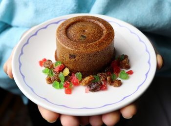 Midsection of person holding sweet food in plate