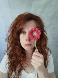 Close-up of young woman holding flower