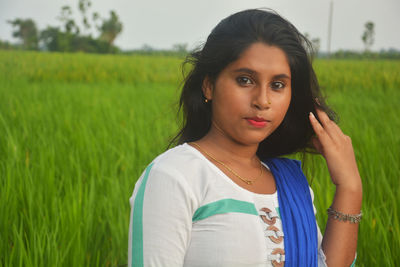 Portrait of beautiful young woman standing in farm