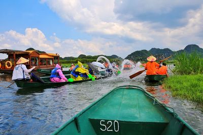 View of people on boat in river against sky